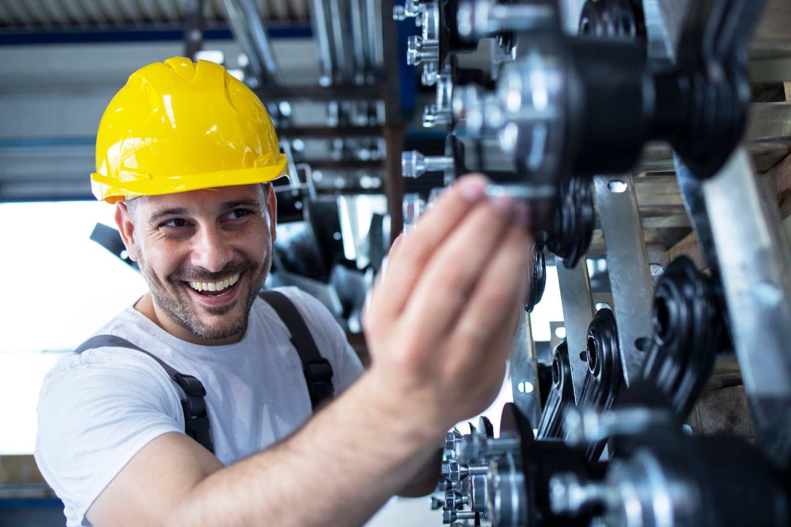 Worker inspecting parts for automobile industry in factory production line.